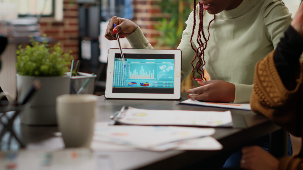 diverse team of people analyzing data charts report on digital tablet